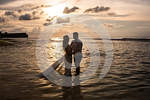 Young couple on the beach at sunset