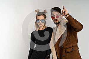 Young couple of bearded man in coat and pretty woman in black dress with long blonde hair