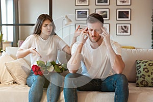 Young couple beautiful woman and handsome man both sitting on the sofa having fight on saint valentine`s day, family drama