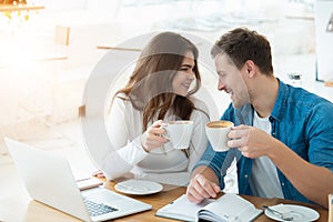 Young couple beautiful woman and handsome man drinking coffee in cafe looking at each other, love and tenderness , relationship