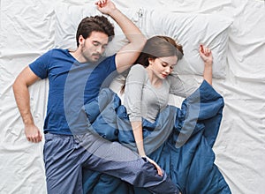 Young couple in bed top view morning concept uncomfortable pose