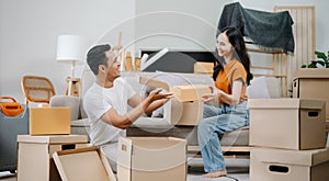 Young couple with big boxes moving into a new house, new apartment for couple, young asian man and woman helping to lift boxes on