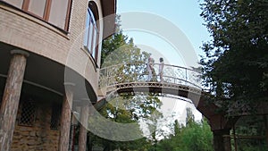 Young couple blond man and brunette woman approach each other on architectural beautiful bridge