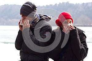 A Young Couple Blowing Their Noses