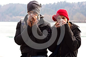 A Young Couple Blowing Their Noses