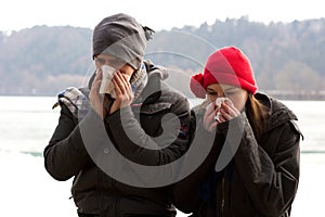 A Young Couple Blowing Their Noses
