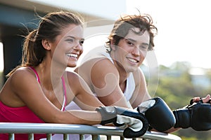 Young Couple in Boxing Gloves Leaning on Railing photo