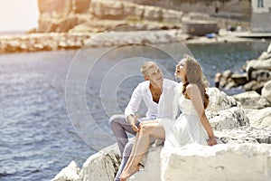 Young couple bride and groom smiling and relaxing near sea, Naples, Italy