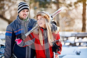 Young couple bring skis on shoulder photo