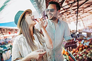 Young couple buying fruits and vegetables in a market