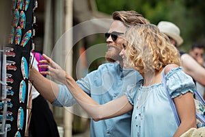 young couple buying new sunglasses outdoor