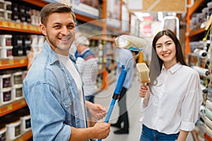 Young couple buying repair tools in hardware store photo
