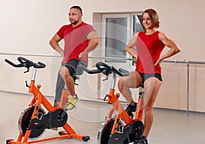Young couple bycicle cycling in gym