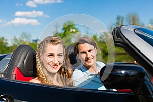 Young couple with cabriolet in summer on day trip