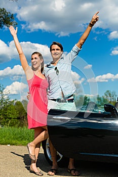 Young couple with cabriolet in summer on day trip