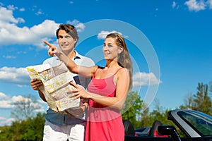 Young couple with cabriolet in summer on day trip