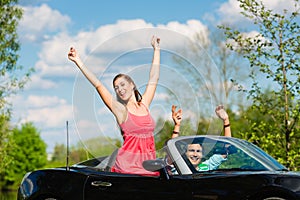 Young couple with cabriolet in summer on day trip