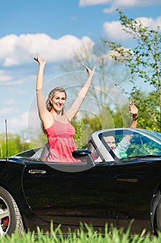 Young couple with cabriolet in summer on day trip