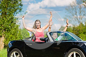 Young couple with cabriolet in summer on day trip