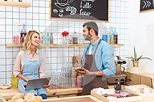 young couple of cafe owners using laptop and smiling each