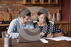 Young couple calculate expenses paying bills on laptop