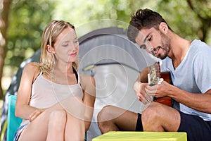 young couple camping playing guitar outdoor