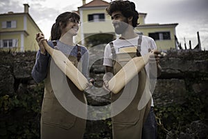 A young couple of carpenters working together in a small carpentry workshop designing a new home furniture piece crafting out of