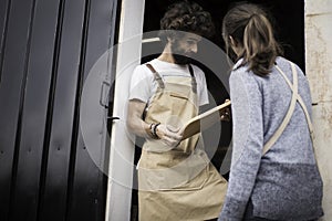 A young couple of carpenters working together in a small carpentry workshop designing a new home furniture piece crafting out of