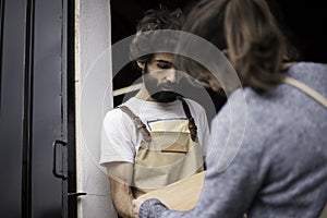 A young couple of carpenters working together in a small carpentry workshop designing a new home furniture piece crafting out of