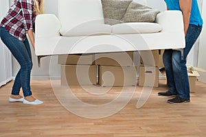 Young couple carrying couch