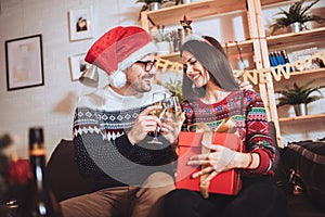Couple celebrating Christmas at home opens gift