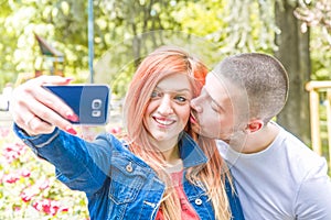 Young couple with cellphone at the park photo