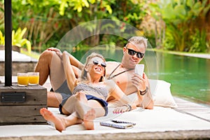 Couple chilling out by the pool on vacation