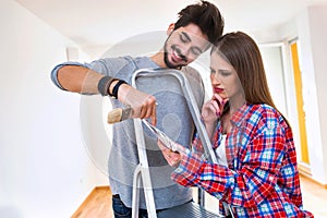 Young Couple Choosing Colors for Painting their Home
