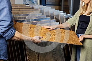 Couple choosing cork floor for home improvements in flooring shop photo