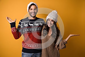 Young couple in Christmas sweaters and hats