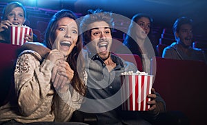 Young couple at the cinema watching an horror movie