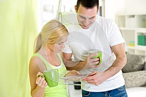 Young couple on coffee break while painting