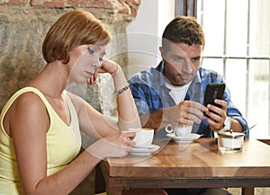 Young couple at coffee shop with internet and mobile phone addict man ignoring frustrated woman