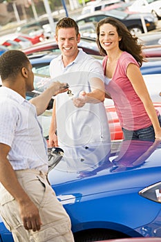 Young couple collecting new car