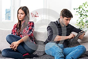 Young couple in conflict, a guy with a tablet