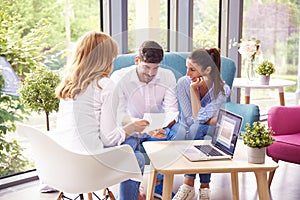 Young couple consulting with investment advisor businesswoman