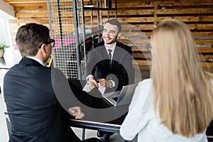 Young couple consulting at manager in modern office.