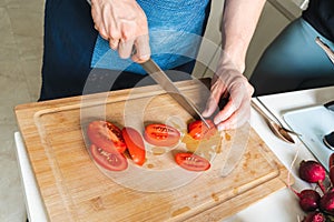 Person chopping vegetables, to make a salad and getting food ready to cook photo