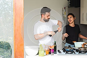Young couple cooking healthy food together at home. Interior of a Latin American home photo