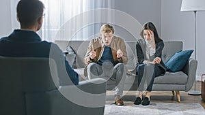 Young Couple on Counseling Session with Psychotherapist. Back View of Therapist Taking Notes: Angry