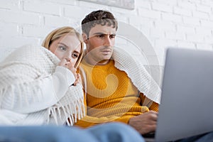 young couple covered in blanket watching