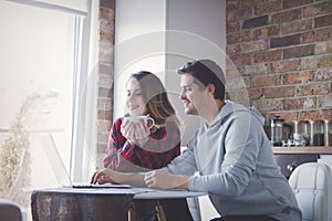 Young couple creating family budget on laptop computer