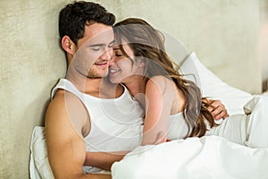 Young couple cuddling on bed photo