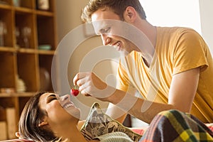 Young couple cuddling on the couch under blanket